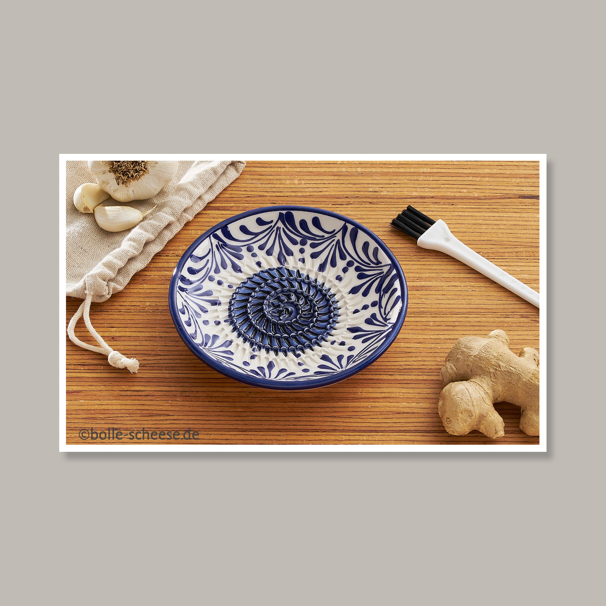 Keramische Kuechenreibe in weiss-blau mit blauen Ornamenten im Set mit Pinsel und Stoffbeutel. 