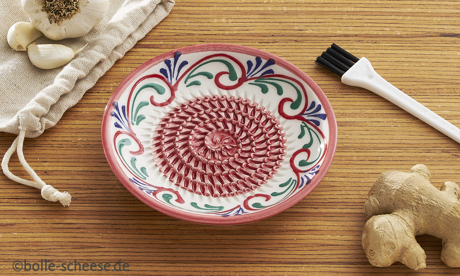 Keramische Kuechenreibe aus Andalusien mit handgemaltem Muster in blau und rot.